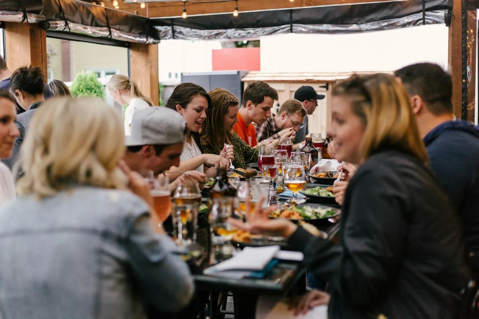 Group of friends sharing a meal on a busy restaurant patio